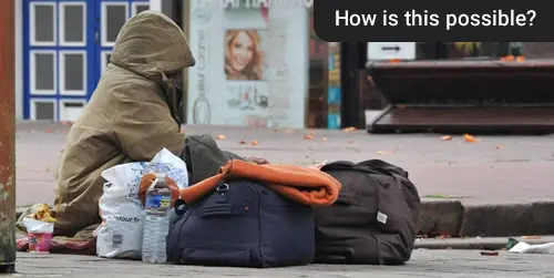 Obdachlose Person mit Habseligkeiten in einer Innenstadt.