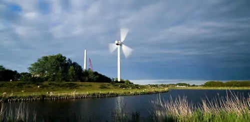 Wind turbine near water and greenery landscape