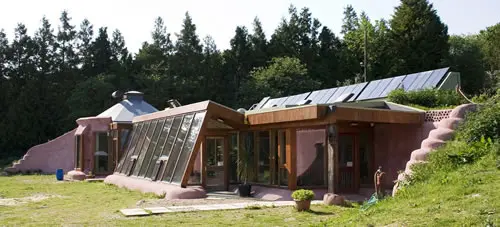 Nachhaltiges Earthship-Haus mit Solarpaneelen.
