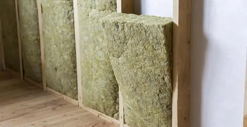 Einbau von Dämmung in eine Holzwandkonstruktion.