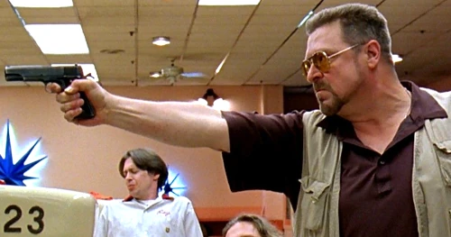 Man pointing a gun in a bowling alley.