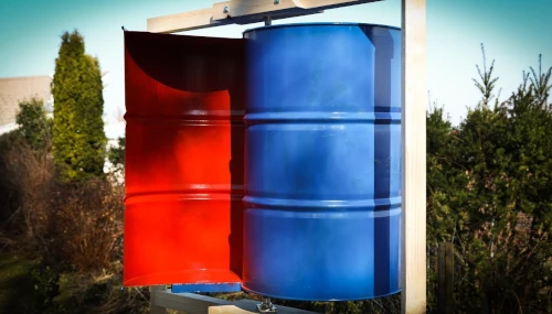 Colorful red and blue metal barrel outdoors.