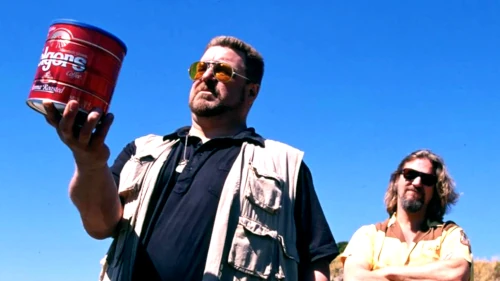 Two men outdoors, one holding a red can.