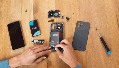 Person disassembling smartphone on wooden table