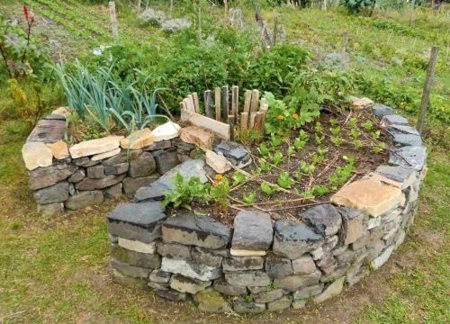 Runder Garten mit Pflanzen und Steinmauern