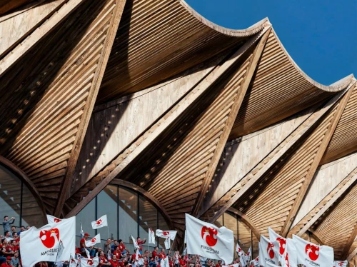 Pavillon en bois avec foule tenant des drapeaux.