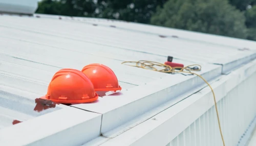 Casques rouges sur un toit métallique blanc.